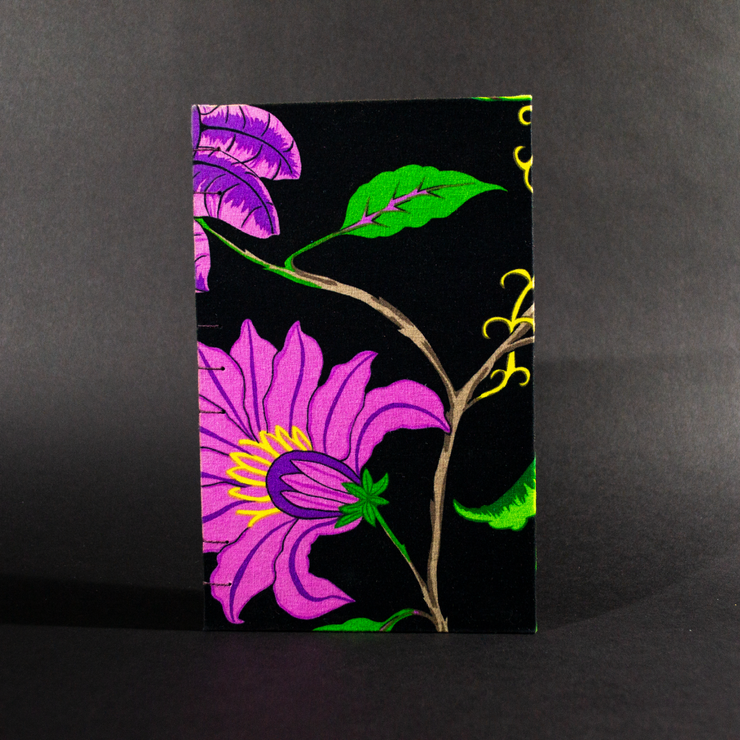 Black floral quarto Coptic bound journal front cover with large bright pink flowers on a black background