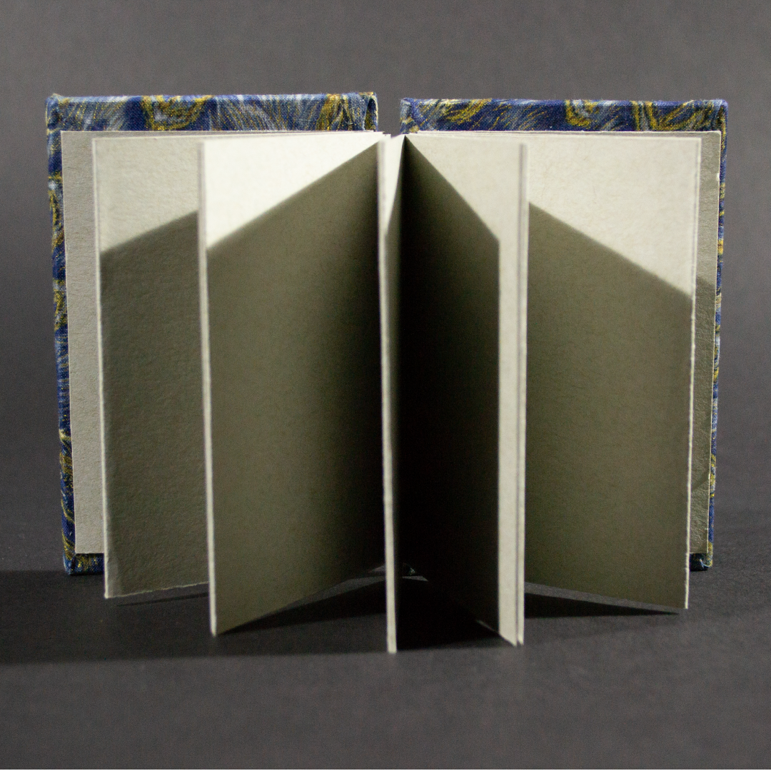 The front cover of the peacock medium accordion book has heavy gray inside pages.