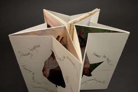 This photo is a front and top down view of two nested accordion structures that are arranged in a circle to form a star. The inside pages are covered in photos of dancers and the front has poetry surrounding cut out leaves. This structure is a Carousel book class example by Laurel Tree Bindery.