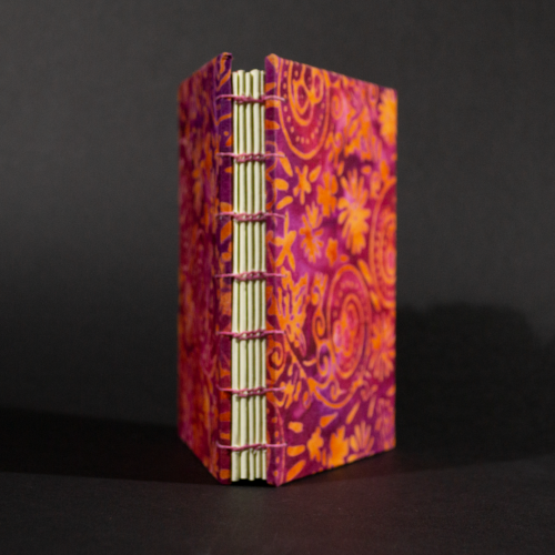 Spine of orange floral batik octavo Coptic book