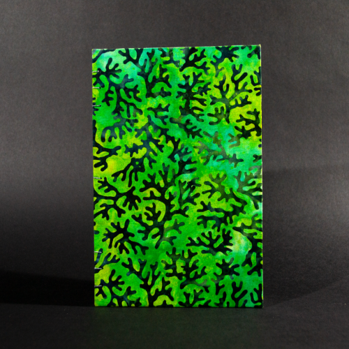 The front cover of blue coral batik quarto Coptic book with blue coral designs on a blue and green background.