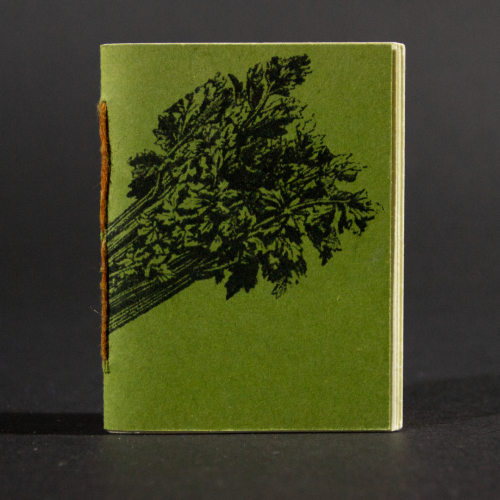 A celery stick wraps around the green front cover of this mini pamphlet book