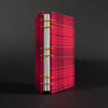 Spine view of red plaid octavo Coptic bound journal with inside white end pages and text pages