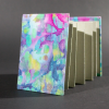 The front cover of the blue batik medium accordion book with blue, pink, and yellow organic shapes; and gray inside pages.